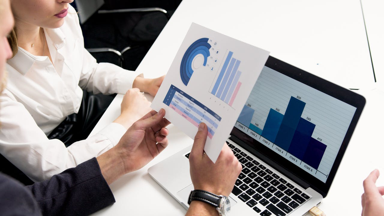Home Business professionals discussing data charts and graphs in a modern office setting.